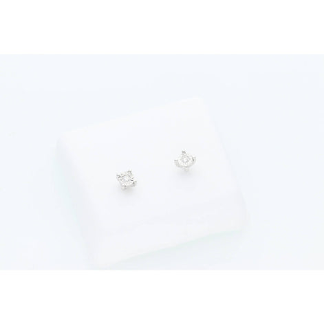 A pair of white gold stud earrings with diamonds set on a white earring stand against a white background.
