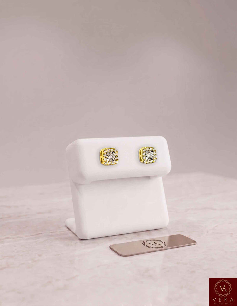 A pair of 0.24 CTW round brilliant lab-grown diamond halo stud earrings in 10k yellow gold, elegantly presented on a white display stand. Veka Jewelry fine fine jewelry collection