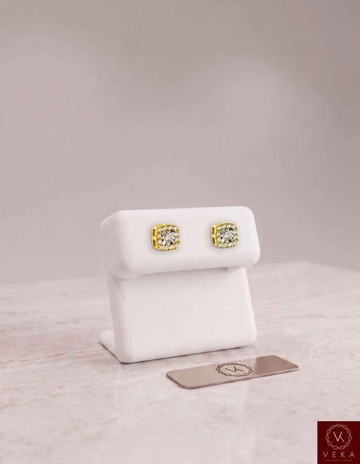 A pair of 0.24 CTW round brilliant lab-grown diamond halo stud earrings in 10k yellow gold, elegantly presented on a white display stand. Veka Jewelry fine fine jewelry collection