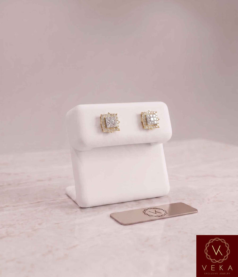 Pair of 0.35 CTW square halo natural diamond stud earrings set in 14K yellow gold, resting on a white Veka Jewelry display stand