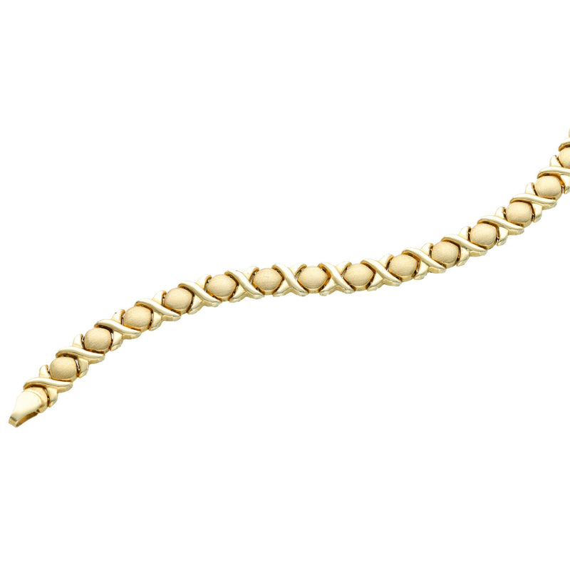 Close-up of  a classic bold 7.7mm 10K yellow gold XOXO Hugs & Kisses Stampato bracelet  in white background,