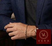 Close up of a 10K gold mariner bracelet showing the secure lobster lock clasp and two-tone center bar details.