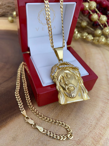 10K solid gold Jesus face pendant with Italian Cuban curb chain on a red leatherette red wood box. Where the Pendant shows how big the bail is and the lobster lock of the chain too.