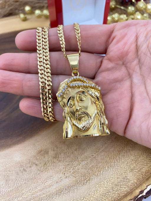 10K solid gold Jesus face pendant with Italian Cuban curb chain on a hand to have a size reference. Where the Pendant with clear stones shows details and how big the bail is and the lobster lock of the chain too.