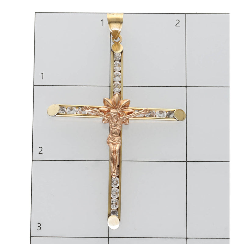10K two-tone gold crucifix on a ruled background