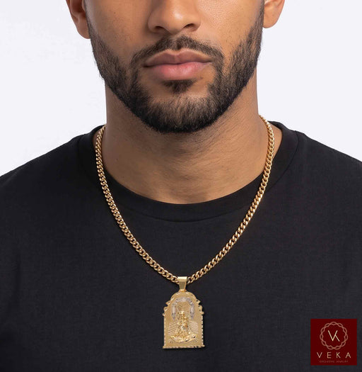 Male model wearing the 10K two-tone gold Caridad del Cobre pendant on a gold Cuban link chain over a black t-shirt
