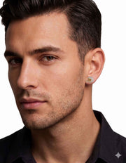 A male model wearing a 10k gold football helmet stud earring paved with 3/8 ctw natural diamonds by VEKA JEWELRY.
