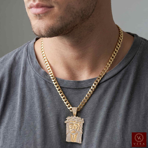 Men's 10K solid yellow gold diamond Jesus face pendant worn on a cuban chain by a male model