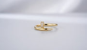 Studio shot of a 10K gold wrap ring designed like a bent nail, featuring pave cubic zirconia stones on the head and tip.