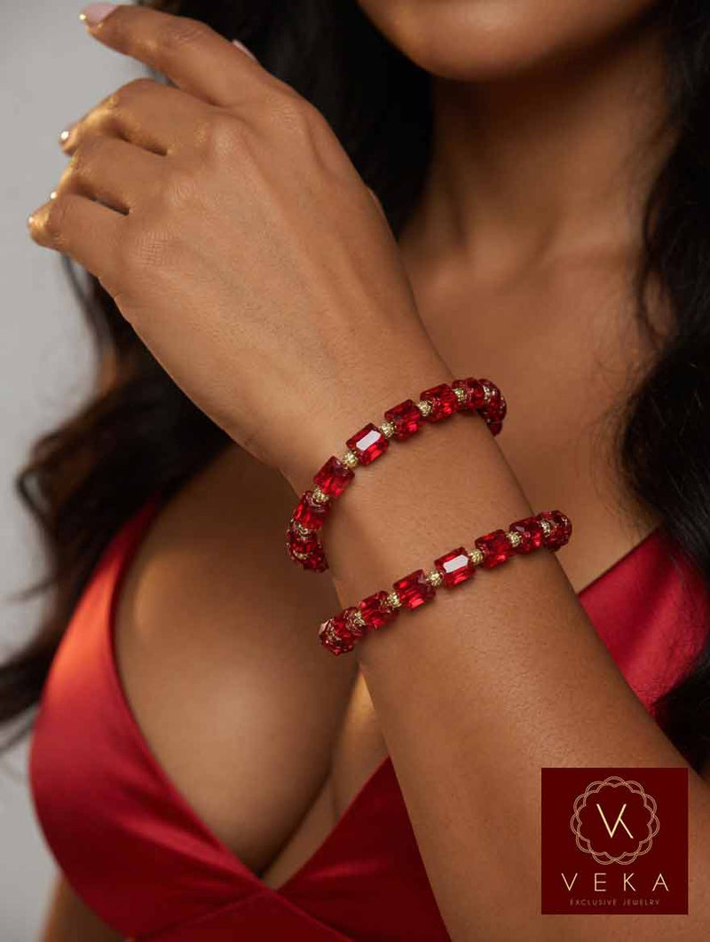 Woman wearing stack of 10K yellow gold pink Swarovski crystal adjustable bracelets on her wrist