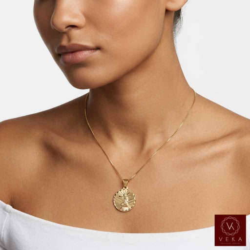 Close-up of woman wearing the 10K yellow gold Saint Lazarus medallion pendant necklace on gold chain by Veka Jewelry