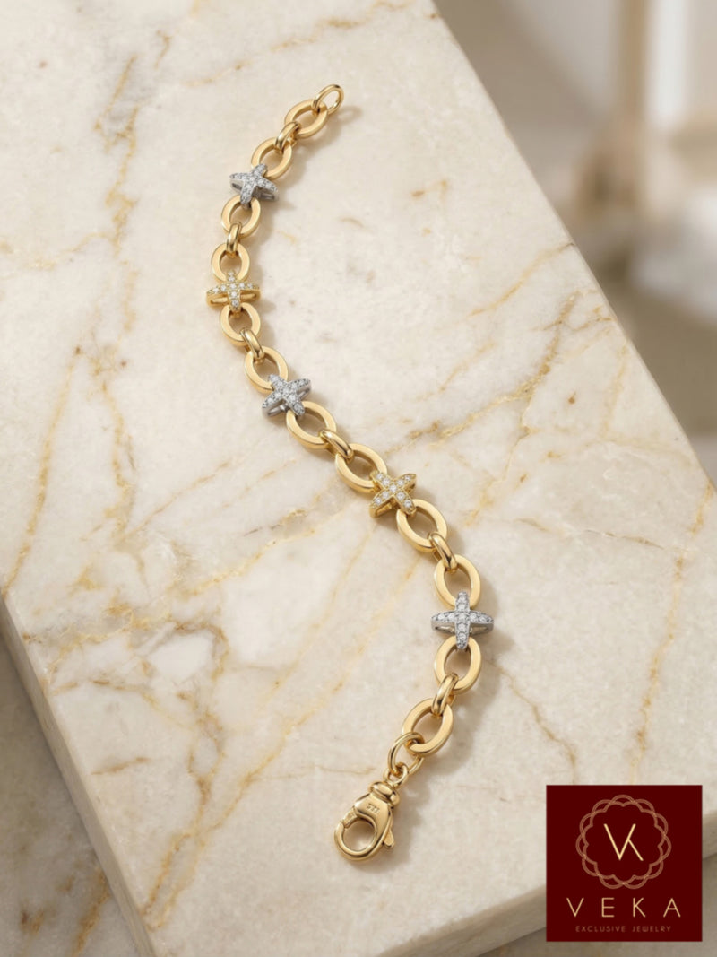 Close-up of a 10k two-tone gold bracelet with five CZ star charms on a white marble background, showing 7mm oval rolo links