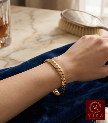 Close-up lifestyle shot of a woman wearing a 10K yellow gold tight link Cuban bracelet on a blue velvet surface, showcasing the Italian craftsmanship and high-shine finish.