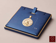 10K two-tone yellow and white gold Santa Barbara diamond-cut medal pendant 43mm presented on a navy blue jewelry display tray by Veka Jewelry