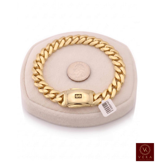 Close-up of a 10K yellow gold Monaco Chain Classic Plain Bracelet in 15.5mm, showcasing the high-polish links and black enamel detailing on a white shirt background