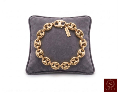 10mm puff mariner link bracelet in 14K yellow gold displayed on a grey velvet pillow by Veka Jewelry