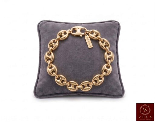 10mm puff mariner link bracelet in 14K yellow gold displayed on a grey velvet pillow by Veka Jewelry