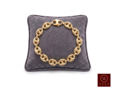 10mm puffed mariner link bracelet nugget textured in 10K yellow gold displayed on a grey velvet pillow by Veka Jewelry