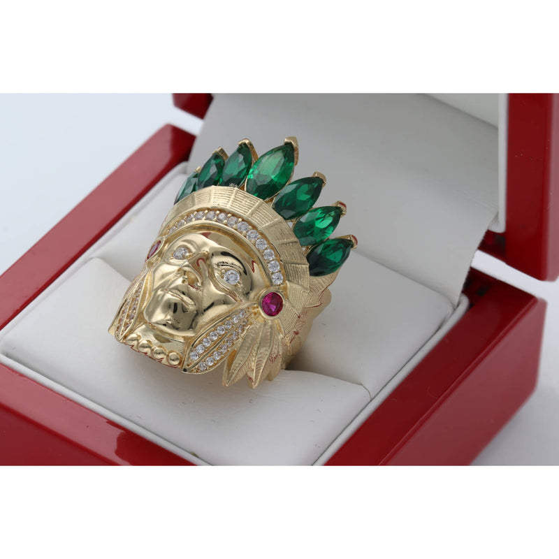 Close-up angled view of the Men's 14K Yellow Gold Indian Chief Ring (13.3g) by Veka Jewelry, featuring a detailed headdress set with emerald green marquise-cut synthetic stones and clear cubic zirconia accents, displayed in a red ring box