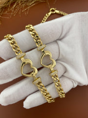 Two 14K gold heart bracelet placed on hand covered by a luxury white cloth glove.