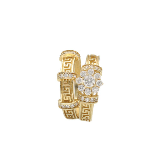 A 14 karat gold dual-tone wedding ring set with a geometric maze design, featuring a prominent zirconia flower on one of the rings.
