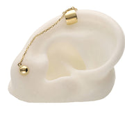 Ear silicone model with a 14K yellow gold ear cuff connected to a ball stud earring by a delicate gold chain. Stylish helix-to-lobe jewelry by VEKA Jewelry.
