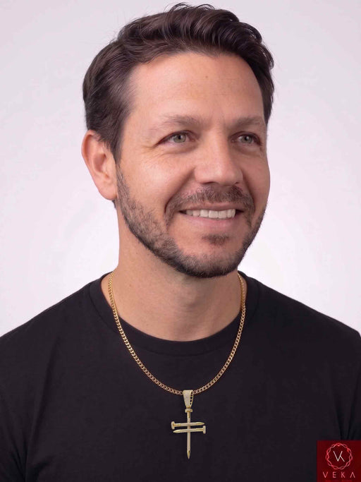 A smiling male model with a black sweater on with a cuba gold chain with a 14k gold nail charm adorned with clear cz stones medium large size