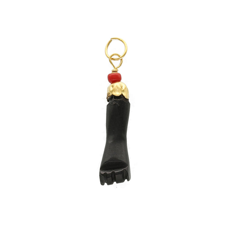 A 14 karat gold black figa hand real azabache pendant with a red coral attachment.