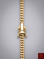 Close-up detailed shot of a secure premium box lock clasp on a 14K solid gold 4mm Miami Cuban link chain by Veka Jewelry.