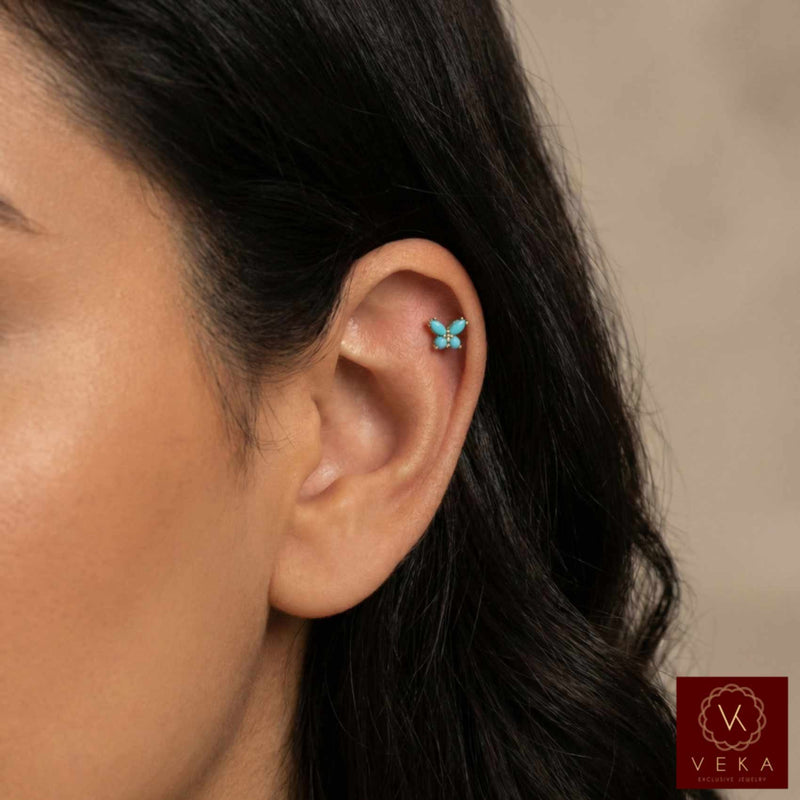 14k yellow gold butterfly cartilage stud with turquoise stones worn on a helix piercing. Flat back labret jewelry by VEKA Jewelry.