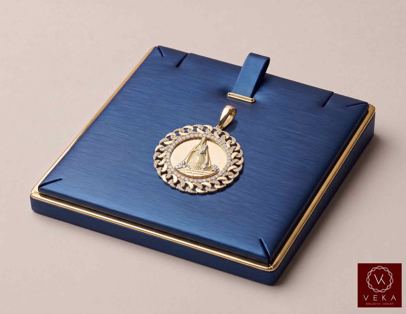 14K yellow gold Caridad del Cobre medal pendant with CZ Cuban link border displayed on a luxury navy blue jewelry tray by Veka Jewelry