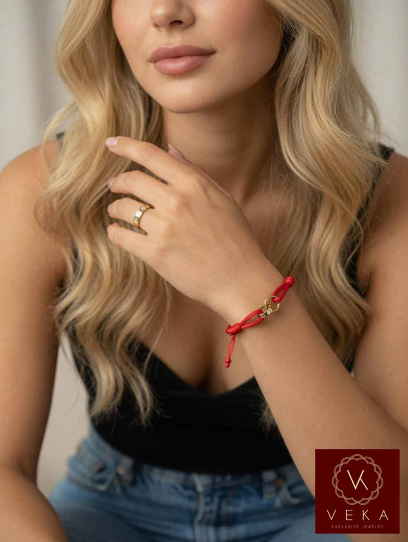 14K gold two band passion red macrame bracelet with screw head design worn on wrist by blonde model in black top and jeans