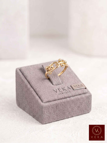 14K solid yellow gold interlocking link band ring with sphere accents on a gray Veka Jewelry display stand