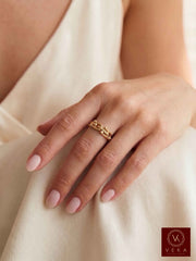 Woman wearing the 14K solid gold interlocking link statement band ring on middle finger - Veka Jewelry