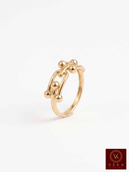 A 14k Interlocking gold ring with an abstract, organic chain-like design accented by small metallic beads, shown on a clean white background with a Veka logo in the bottom right corner.