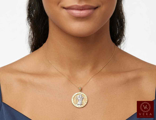 Female model wearing the solid 14K two-tone gold Saint Christopher medallion pendant on a thin gold chain against a clean background