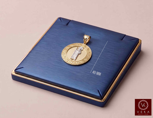 14K two-tone gold St. Jude Greek key medallion pendant on a luxury navy display stand by Veka Jewelry