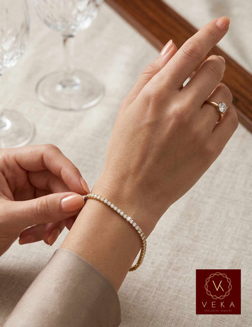 Professional model wearing a 14K yellow gold 3.45 CTW VVS natural diamond tennis bracelet by Veka Jewelry