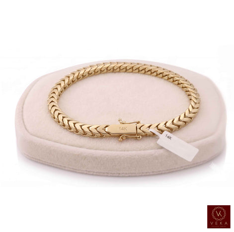 14K yellow gold 5mm Franco chain bracelet resting on a cream velvet pillow display with a Veka Jewelry logo.