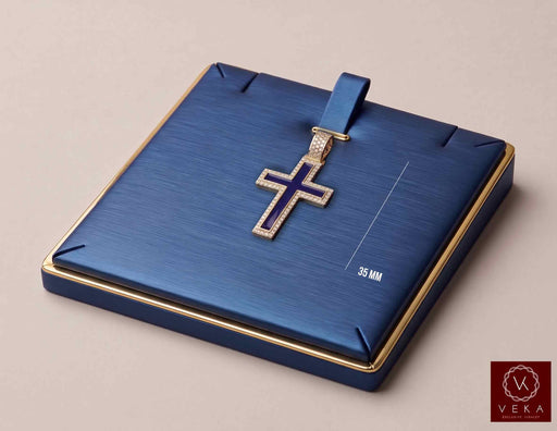 14K yellow gold blue enamel cross pendant with cubic zirconia halo displayed in a luxury navy blue jewelry case by Veka Jewelry.