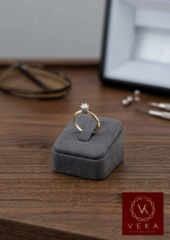VEKA Jewelry 14k yellow gold diamond solitaire ring on grey velvet display base, detailed view.