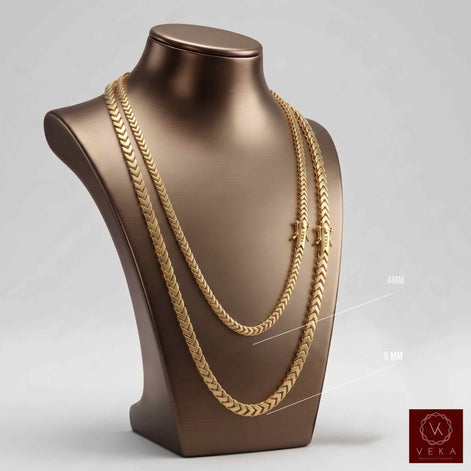 A three-quarter view of a brushed bronze jewelry display bust wearing two lengths of a 4mm 14K yellow gold hollow Franco chain necklace by Veka Jewelry, showing the woven link detail. A small Veka logo is in the corner.