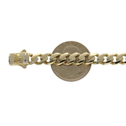 A 14 karat gold anklet with clear zirconia stones with the word ROMA, featuring a Cuban-link design shown on a white background on top of a 25 cent coin to have an idea of the regular size.