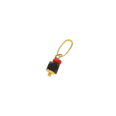 A 14 karat gold azabache charm with a red detail on the top, not polished and rounded square stone.