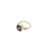 Gold ring with a purple gemstone on a white background