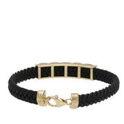 A 14 karat gold leather bracelet with a lobster lock clasp, crossed in a figure-eight style, showing the inside of it displayed on a white background.