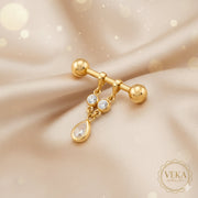14K yellow gold nipple piercing barbell with teardrop dangle and round crystals on luxury champagne silk background - Veka Jewelry