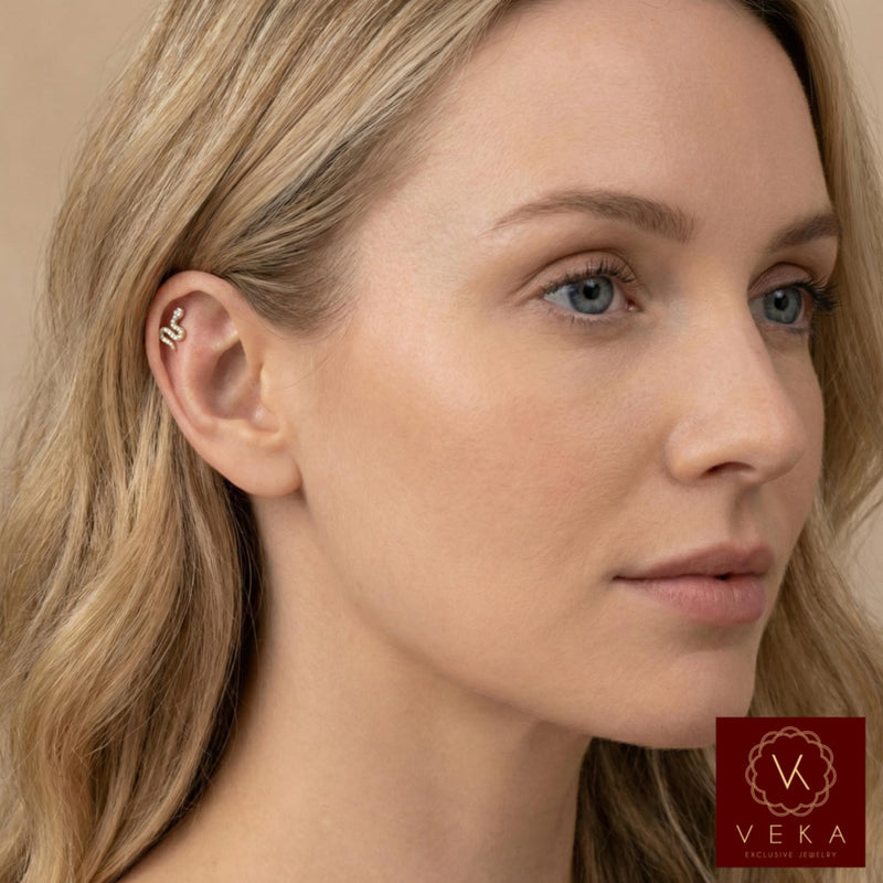 Close-up profile of a blonde woman wearing a 14k gold and pavé stone snake flat back stud in her upper helix cartilage piercing. Luxurious ear scape jewelry by VEKA Jewelry.