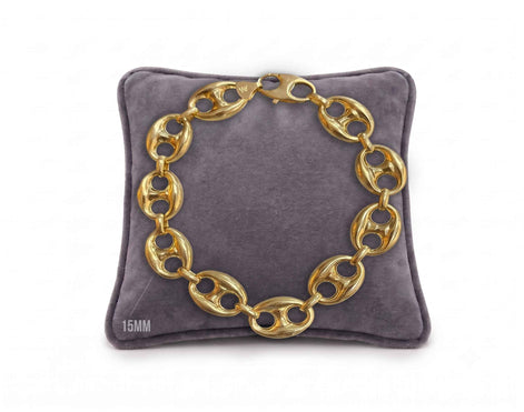 15mm puffed mariner link bracelet in 10K yellow gold displayed on a grey velvet pillow by Veka Jewelry