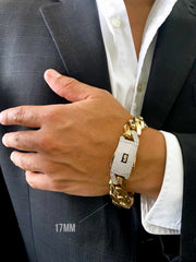 A close-up of a man's hand wearing a 10K Gold Monaco gold and Zirconia-encrusted stones wristband bracelet, styled with a white dress shirt and dark suit jacket. A text overlay indicates '17MM'.